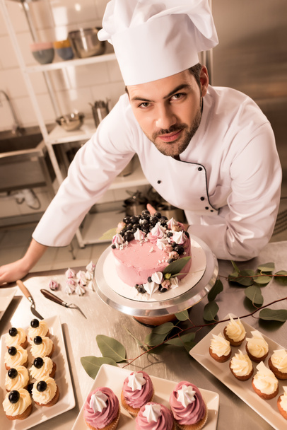 korkea kulma näkymä makeisten seisoo lähellä kakku tiskillä ravintola keittiö
 - Valokuva, kuva