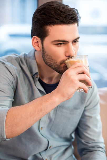portrait of young handsome man drinking ice coffee in cafe - Zdjęcie, obraz