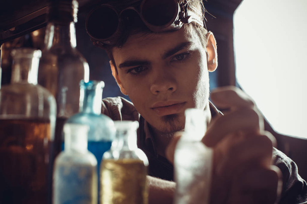 Portrait of a young mad scientist dressed in steampunk style and - 写真・画像