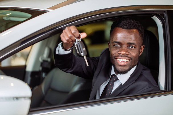 Young African Businessman Sitting In A Car Showing Car Key - Foto, Bild