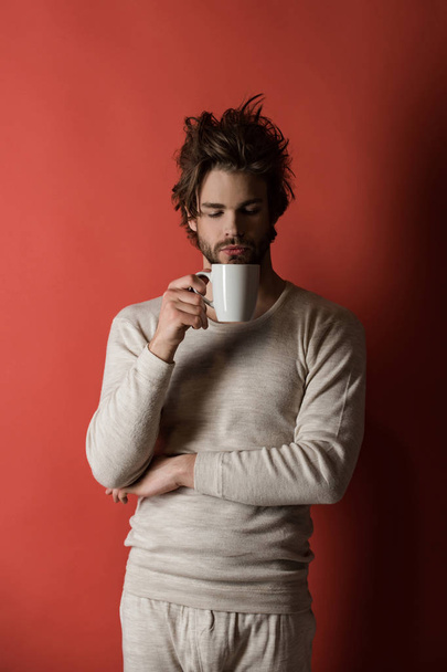 sleepy man with disheveled hair drink coffee in morning, cold - Foto, Imagen