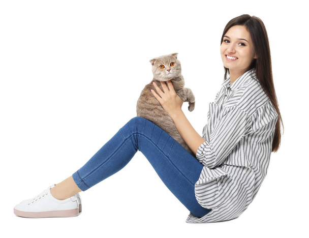 Young woman with cute pet cat on white background - Foto, imagen