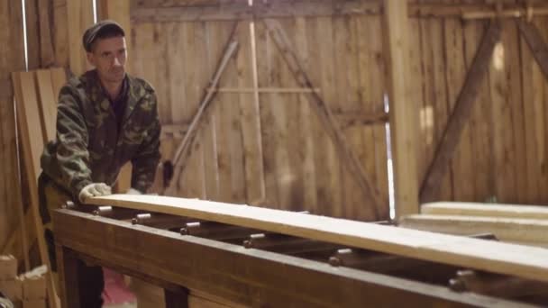 Prkno opertes zaměstnanci krátí tesař tesařských strojů na dřevěné části zařízení - Záběry, video