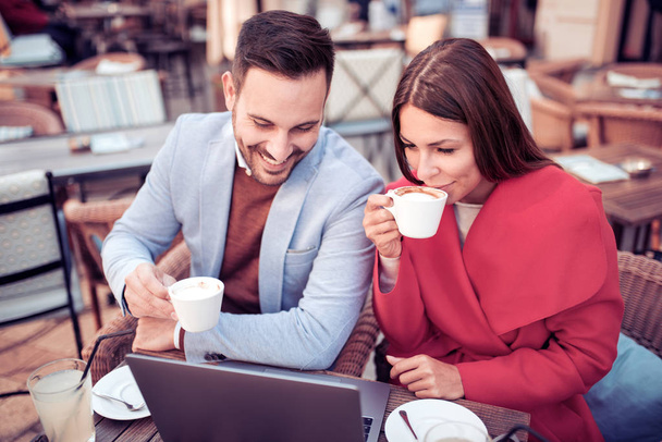 Heureux couple passer du temps ensemble dans un café et travailler sur un ordinateur portable
. - Photo, image