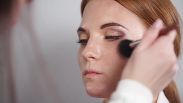 close up shot of a make-up artists hands, who is applying powder with mascara - Felvétel, videó