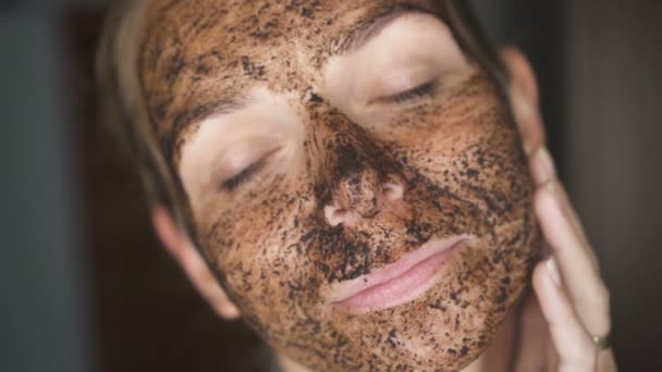 Zbliżenie twarzy kobiety z twarzy maska kawowa - wideo w zwolnionym tempie - Materiał filmowy, wideo