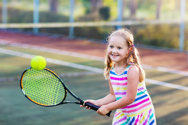 Enfant jouant au tennis sur un court extérieur
 - Photo, image