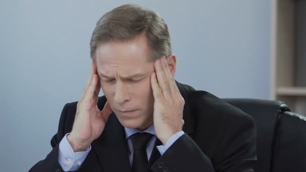Businessman suffers from sick headache, problem at work, stress from overworking - Materiaali, video