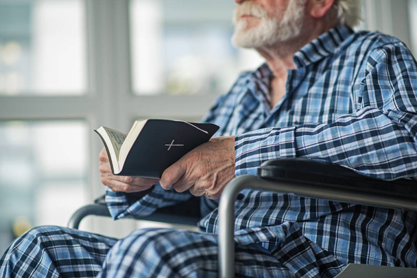 Sénior masculino lendo o livro sagrado no quarto
 - Foto, Imagem