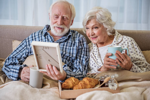 Calm elderly husband and wife having rest at home - Foto, Imagem