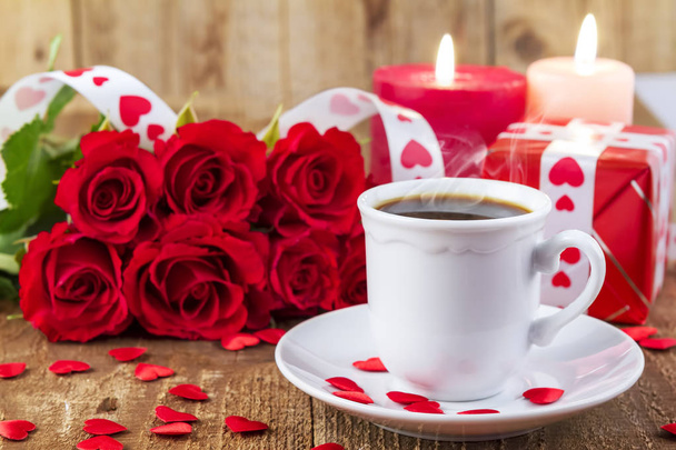 Kuppi kahvia edessä kimppu punaisia ruusuja
 - Valokuva, kuva