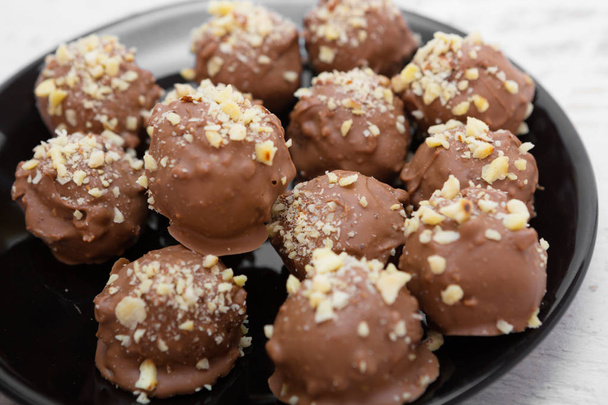 Kézzel készített csokoládé édességek dióval megszórva - Fotó, kép