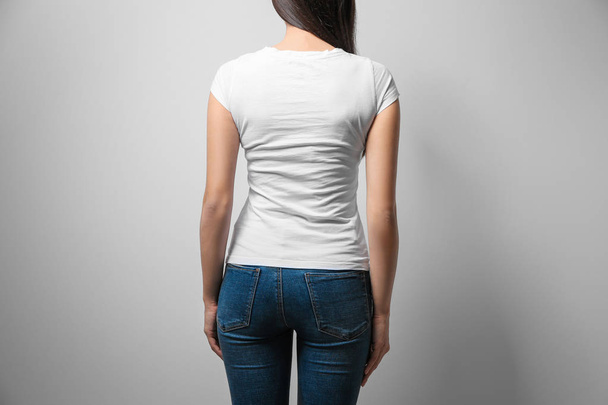 Woman in white t-shirt on light background. Mock up for design - Foto, afbeelding