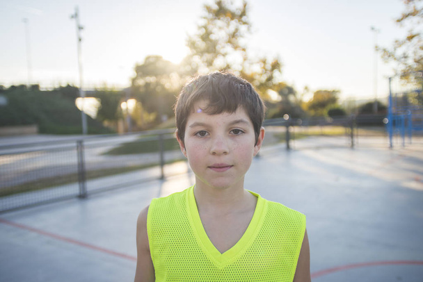Portrait of a young teen wearing a yellow basketball sleeveless - Фото, изображение