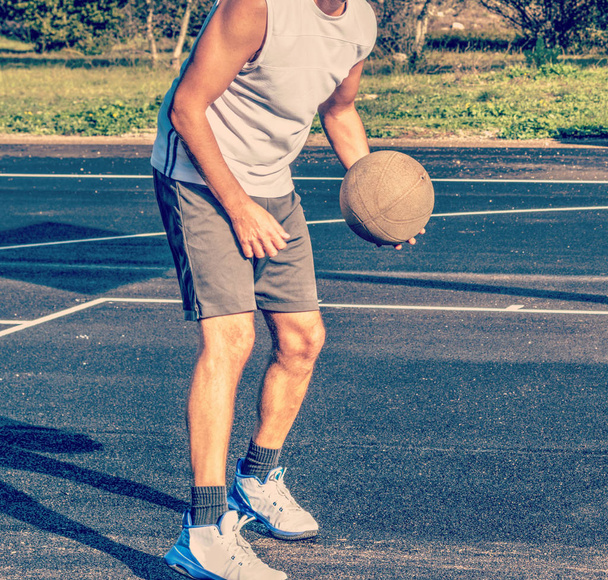 Передній вигляд баскетболіста, який тримає м'яч на ігровому майданчику
 - Фото, зображення