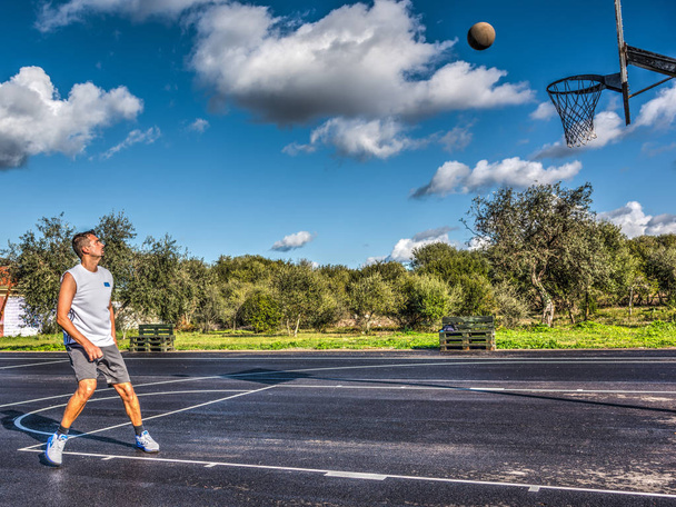 Jugador de baloncesto esperando a que el balón entre en el aro
 - Foto, Imagen