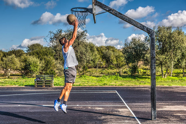 Vista lateral de um jogador de basquete de esquerda
 - Foto, Imagem