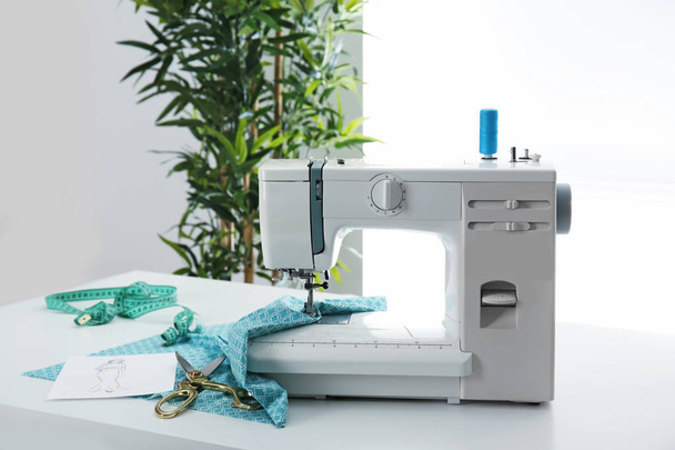 Sewing machine with thread and fabric on table - Фото, изображение