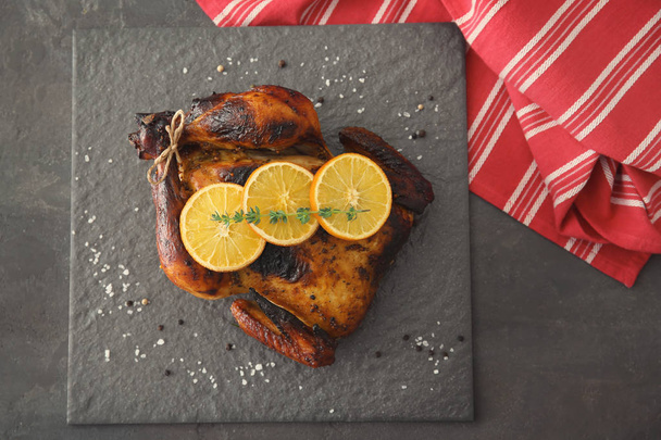 Delicious whole roasted chicken with orange served on slate plate - Photo, Image
