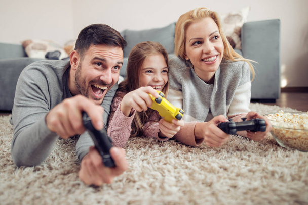 Glückliche Familie spielt Videospiele zu Hause. - Foto, Bild