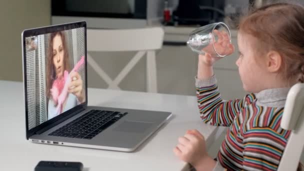 malá holčička mluví s mamkou přes skype pomocí přenosného počítače - Záběry, video