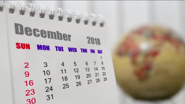 Bewegung des Dezembers 2018 Kalender mit verschwommenem Erdglobus - Filmmaterial, Video