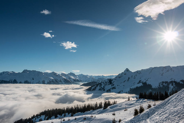 Snow and sun on the top of the mountains and fog down the valley - Photo, Image