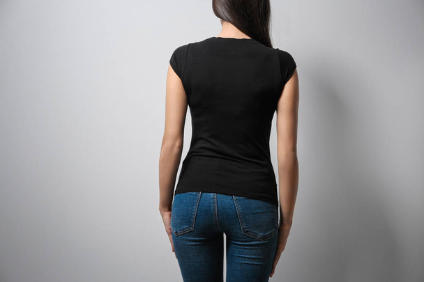 Woman in black t-shirt on light background. Mock up for design - Foto, Bild