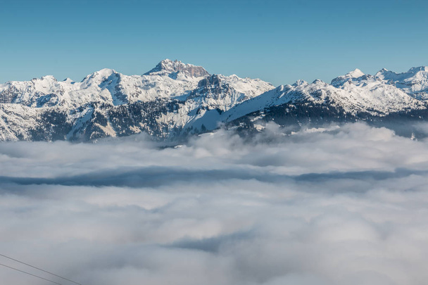 Hó tetején a hegyek és a lefelé a völgyben köd - Fotó, kép