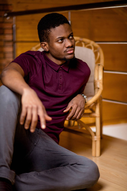 black man sitting on the floor and looking at camera - Φωτογραφία, εικόνα