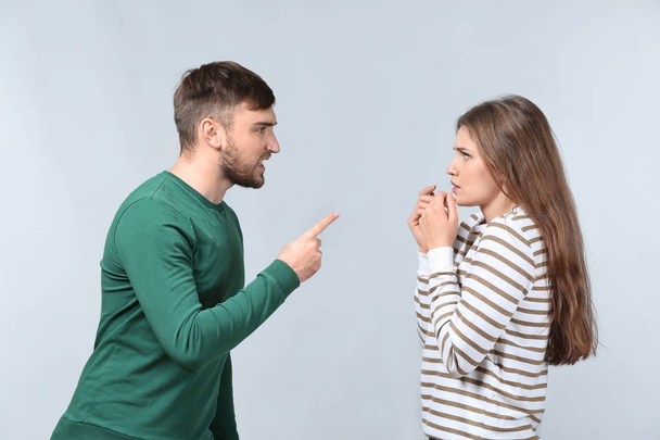 Couple arguing on light background. Problems in relationship - Foto, afbeelding