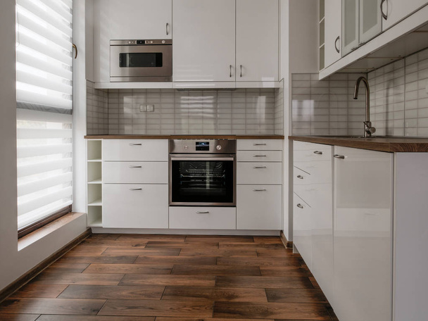 Новая меблированная квартира, маленькая, белая кухня с окном
. - Фото, изображение