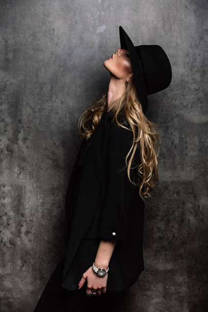 Beautiful young mysterious blond girl in black hat and black jac - Photo, Image