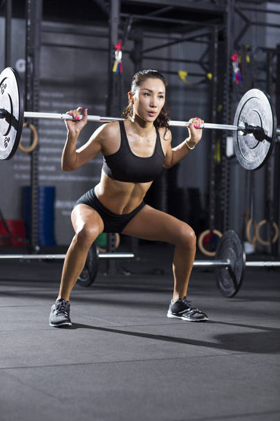 Mujer china levantando barra en el gimnasio
 - Foto, imagen