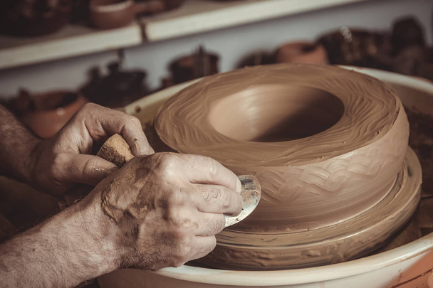 elderly man making pot using pottery wheel in studio - Foto, immagini
