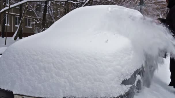 Muž čištění auta od sněhu po velké sněžení - Záběry, video