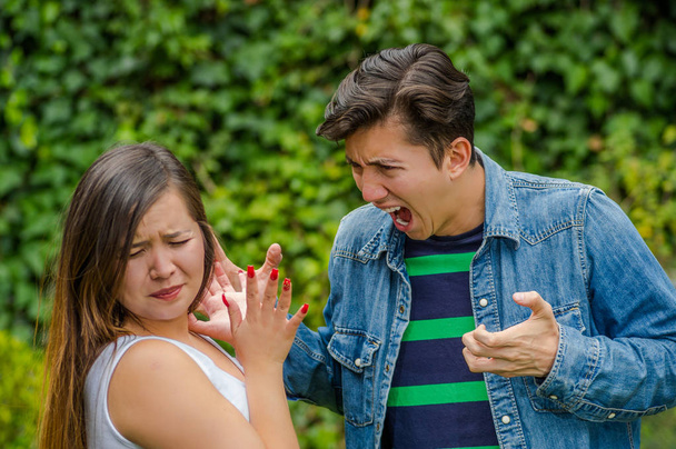Couple fighting. A young man screaming a young woman while the young woman looks terrified, friendzone concept - Foto, Imagem