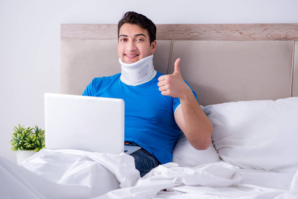 Fiatal férfi nyaksérüléssel az ágyban - Fotó, kép