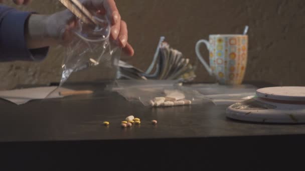 Huumekauppias pakkaa huumeita - tabletteina amfetamiinia tai muuta - pakkauksissa ja punnitsee ne
. - Materiaali, video