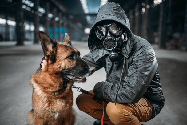 stalker w maskę przeciwgazową i pies, przyjaciół w post apokaliptycznym świecie. Styl życia po Apokalipsie na ruiny, koncepcja doomsday - Zdjęcie, obraz