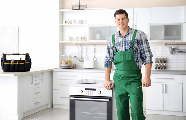 Young worker standing near oven in kitchen - Photo, Image