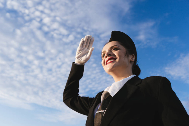 happy woman stewardess in uniform on the sky background - Foto, imagen