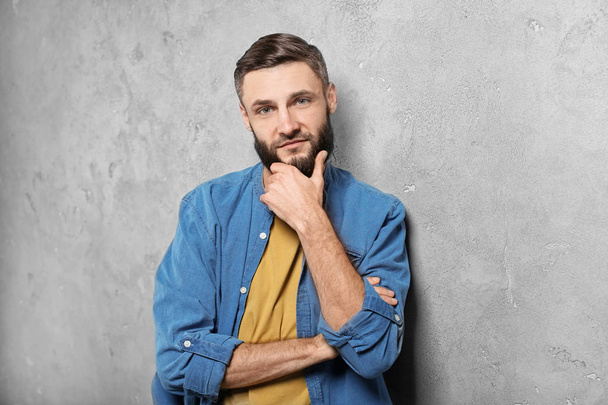 Portrait of handsome bearded man on grey background - Foto, Imagem