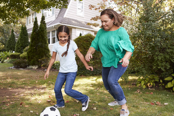 Großmutter spielt mit Enkelin Fußball im Garten - Foto, Bild