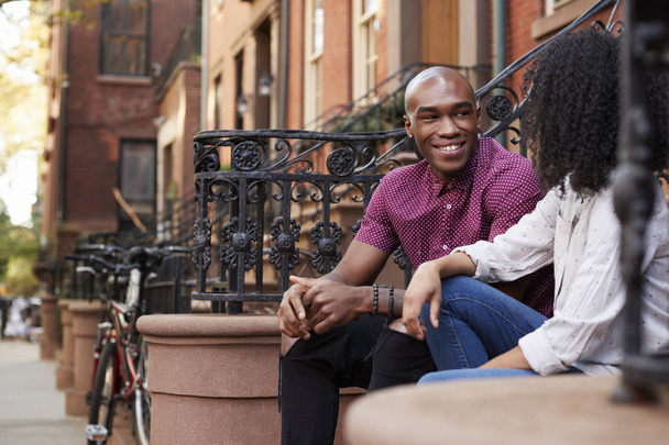 Couple Sit And Talk On Stoop Of Brownstone In New York City - Zdjęcie, obraz