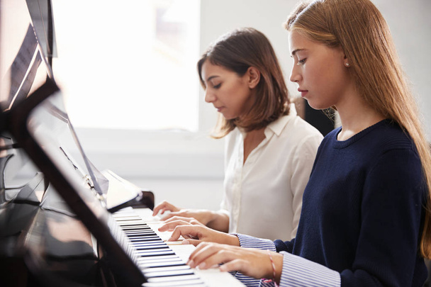 Female Pupil With Teacher Playing Piano In Music Lesson - Zdjęcie, obraz