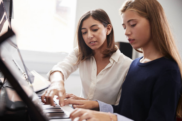 Female Pupil With Teacher Playing Piano In Music Lesson - Fotó, kép