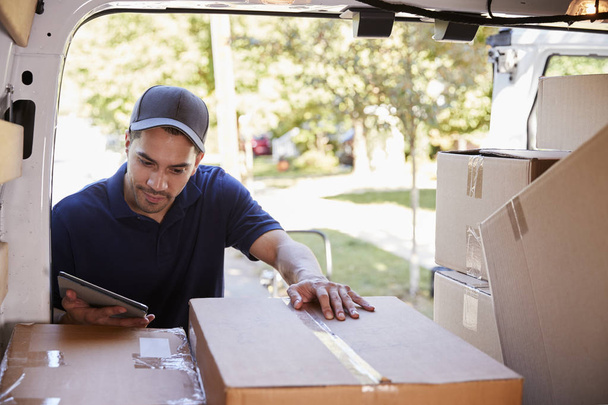 Courier With Digital Tablet Checking Packages In Van - Foto, imagen