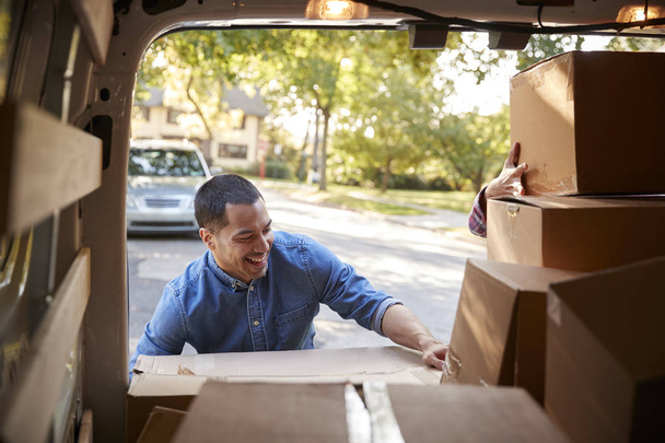 Couple Unloading Boxes From Van On Family Moving In Day - Foto, afbeelding