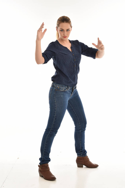 po celé délce portrét dívky nosí jednoduché modrou košili a džínách, stojící pose.isolated na bílém studio pozadí. - Fotografie, Obrázek